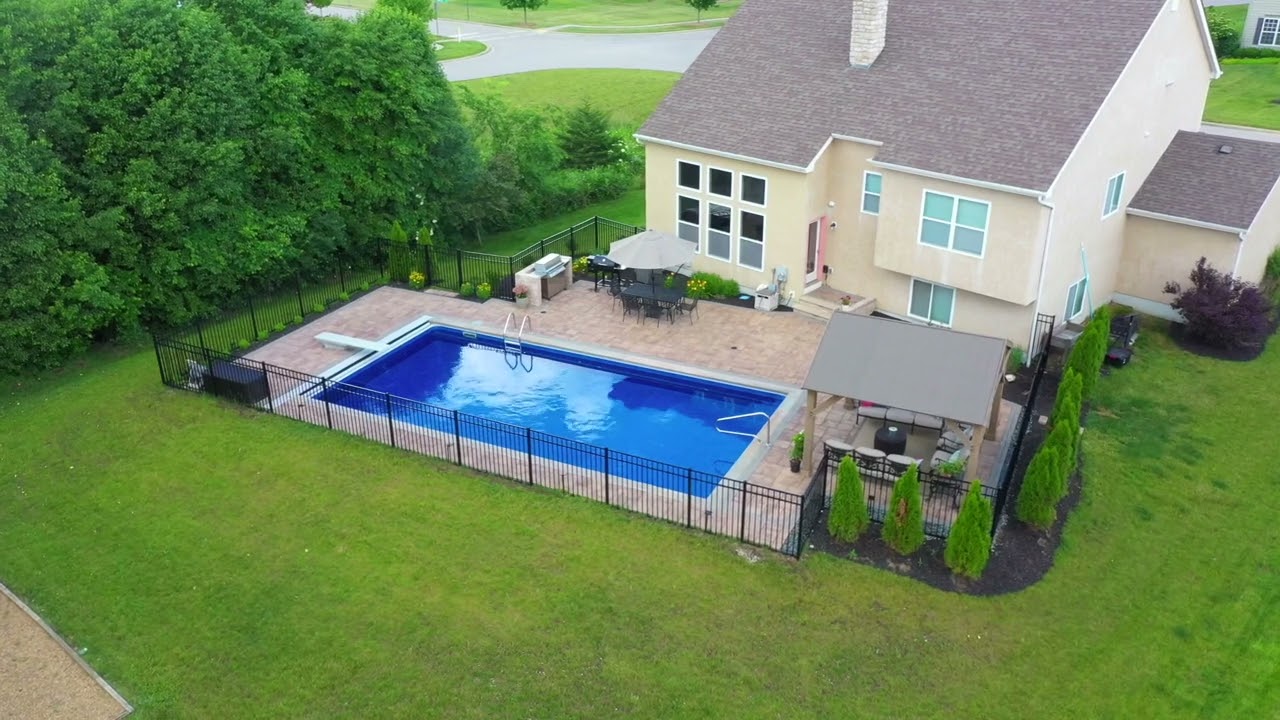 Fiberglass Pool With Diving Board and Patterned Concrete Patio