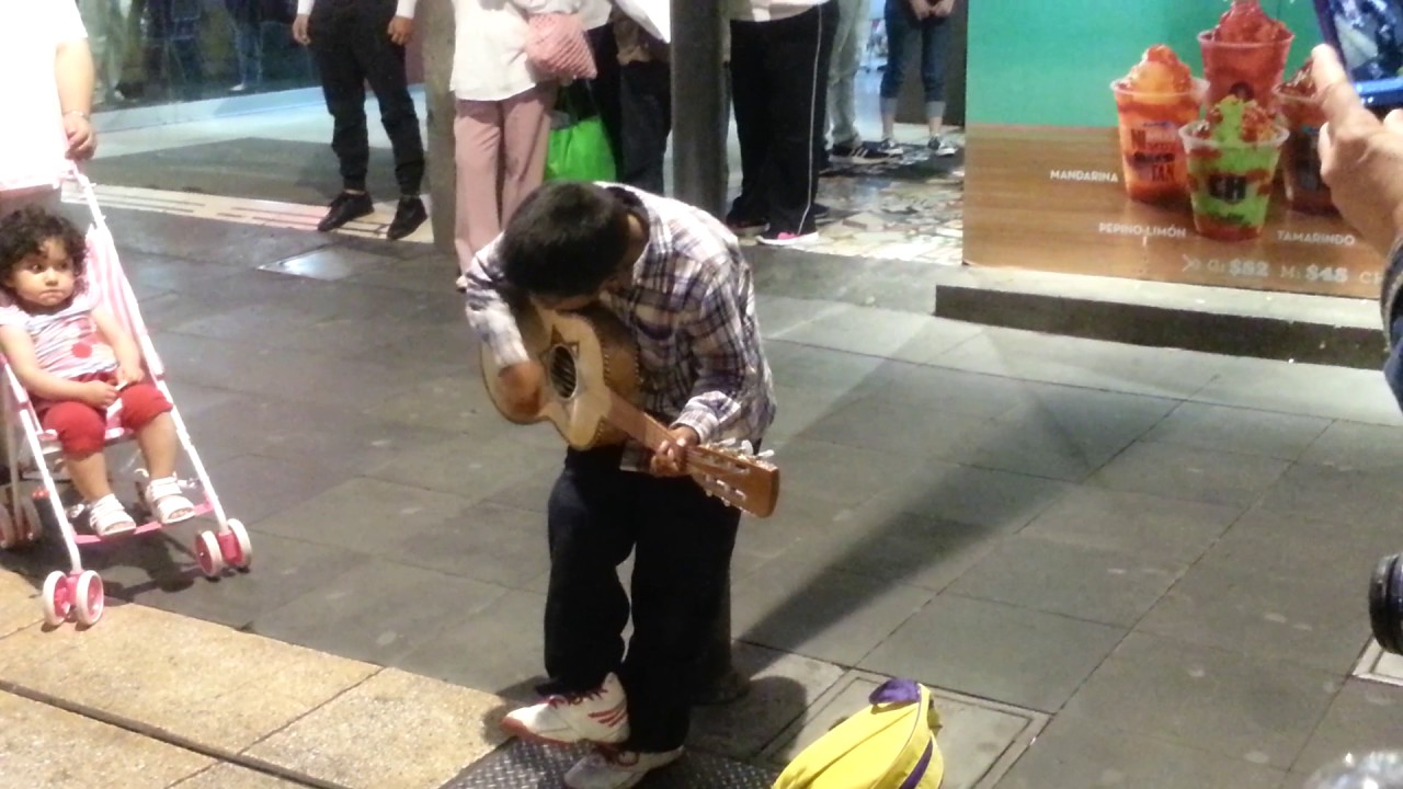 Niño canta y toca para ganarse la vida Trabajando