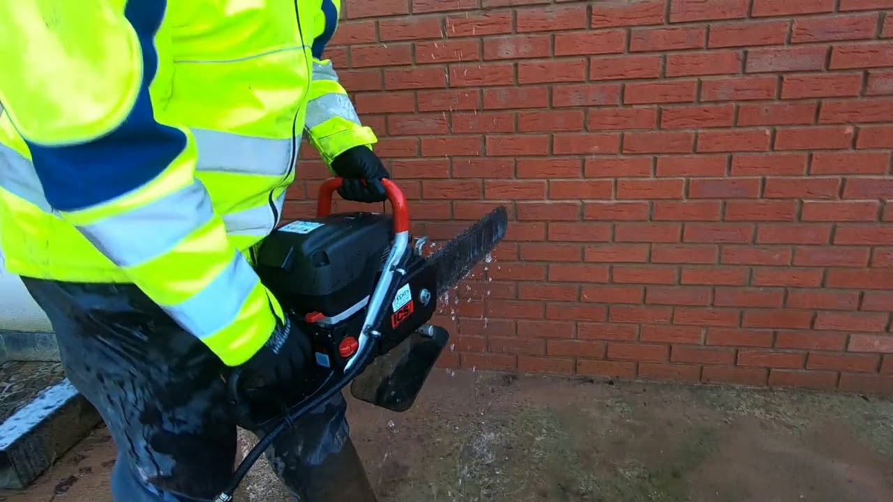 EC Hopkins Cutting Brick wall with Chainsaw