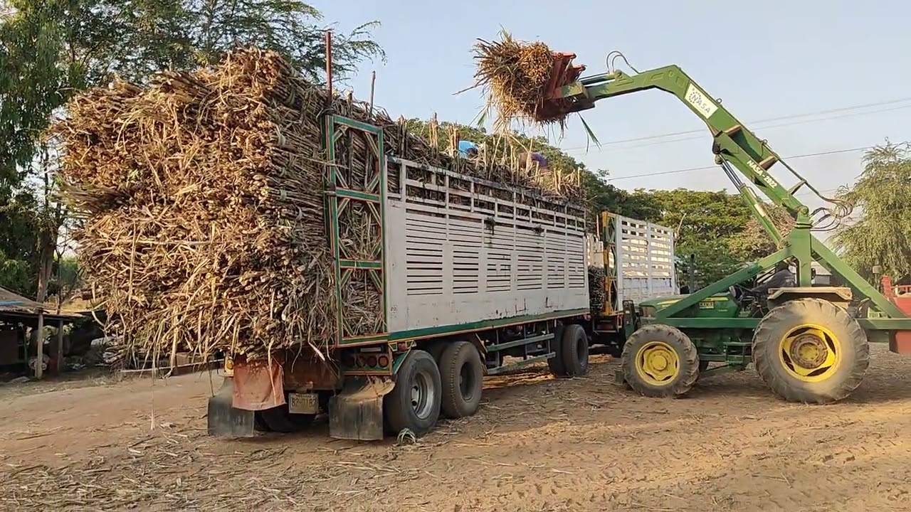Трактор John Deere с захватом для сахарного тростника.
