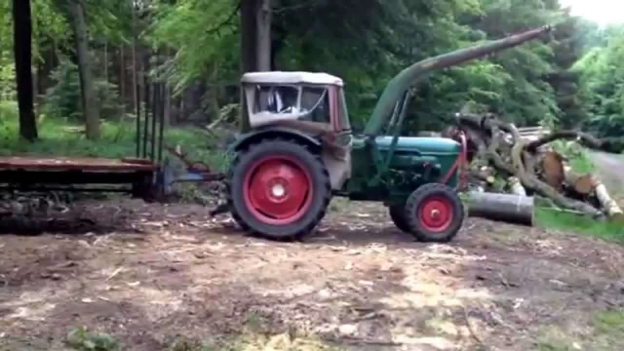 Deutz D40 mit Meterholzanhänger wird im Wald am Holzplatz abgestellt. Holzspalten.