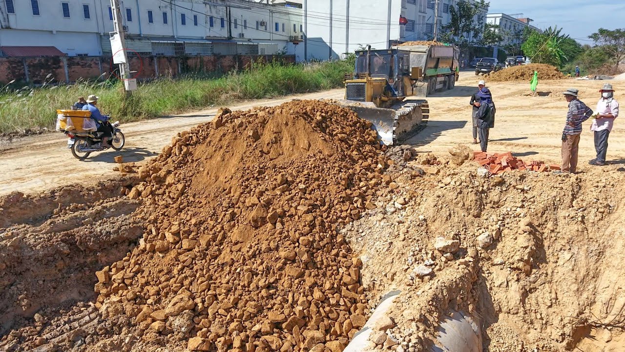 Process repair road in village use Komatsu d41 pushing soil rock with heavy dump truck 