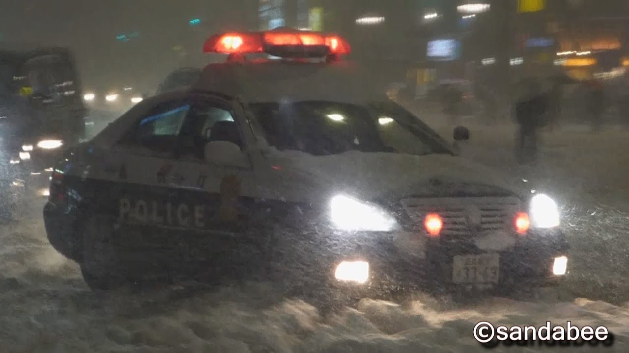 大雪の東京警視庁パトカーの目前を信号無視で逃げ切る4WD車。Flew out from a police car.