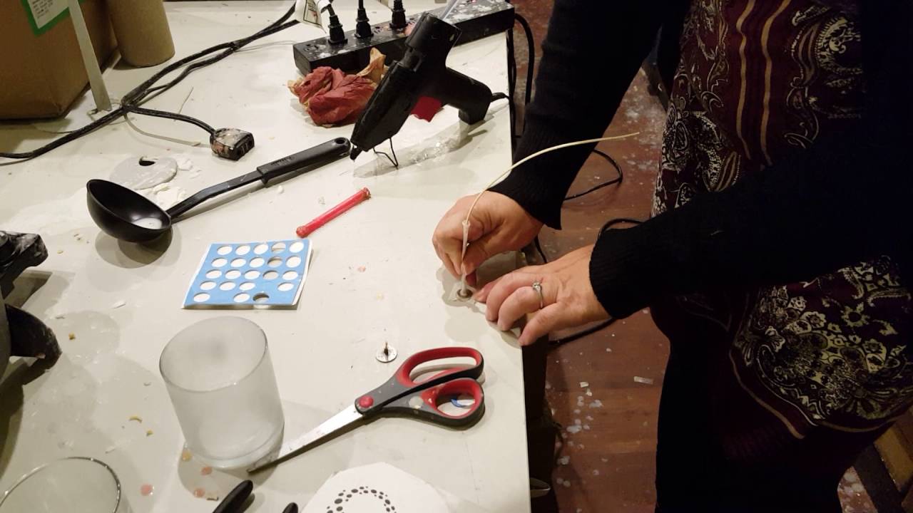 How to adhere a wick to a candle container.