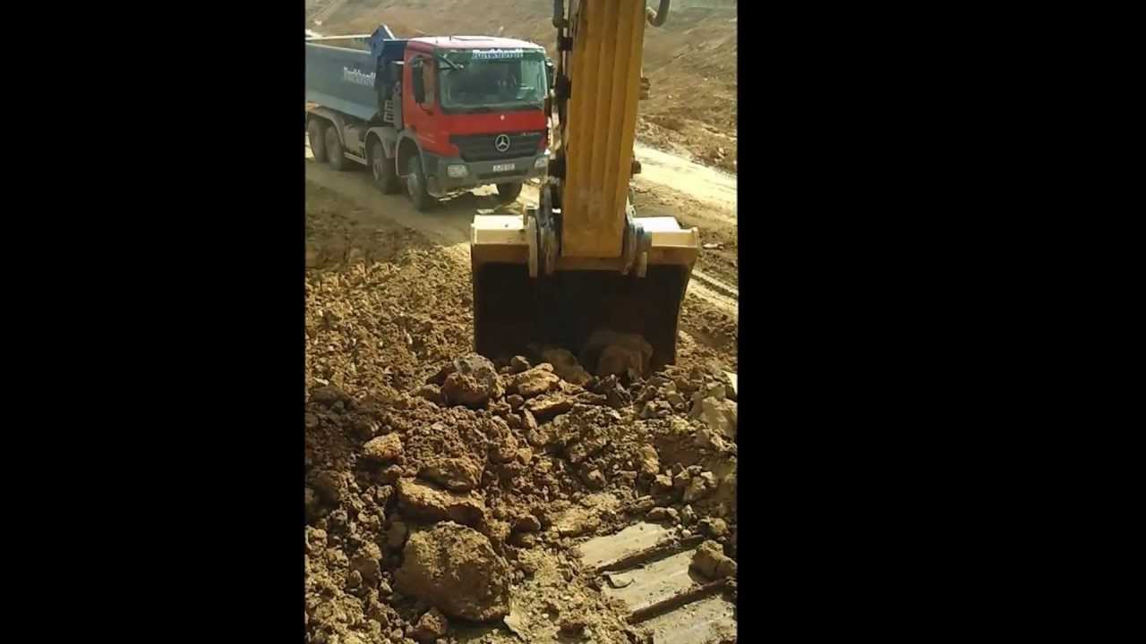 CAT 345 D LME is loading MB dump trucks [Cab view]