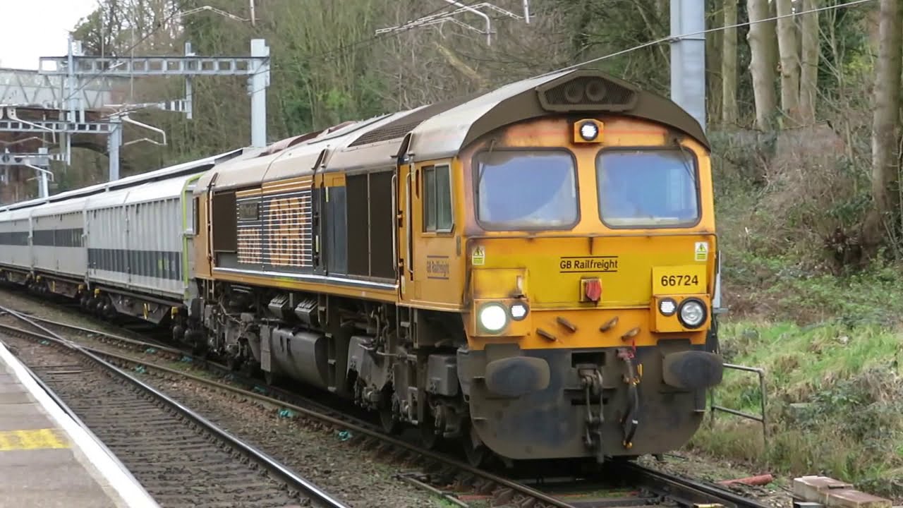 UK: Two GBRf Class 66 locomotives pass Reading West Station with 5 Rail Adventure barrier wagons