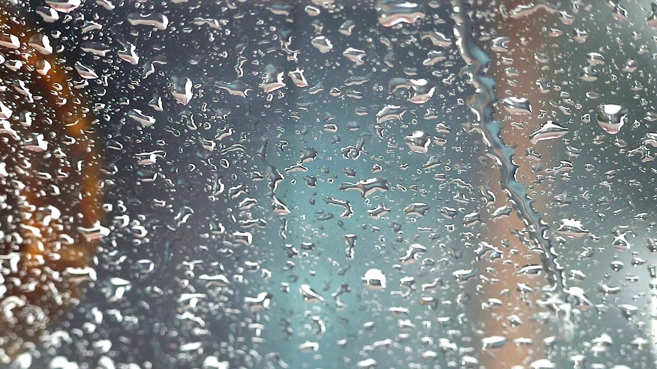 panning and close up to rain drop on the glass of window