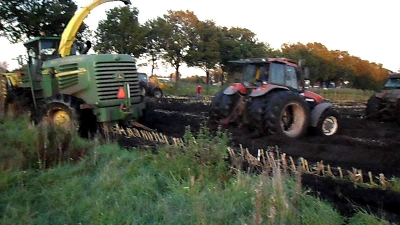 John-Deere 7400 Mais hakselaar  vast in een slootje