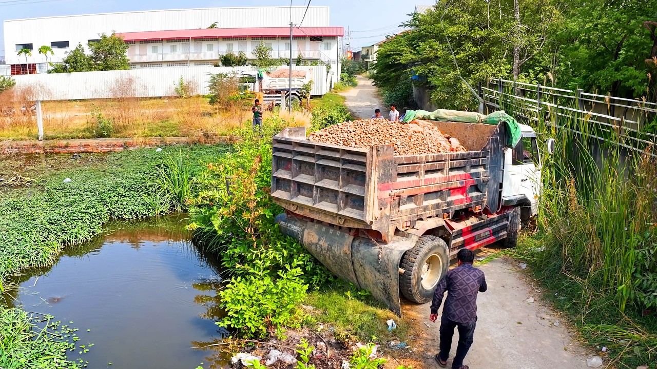 amazing landfill fill build house project ! truck transport soil , bulldozer push soil to water