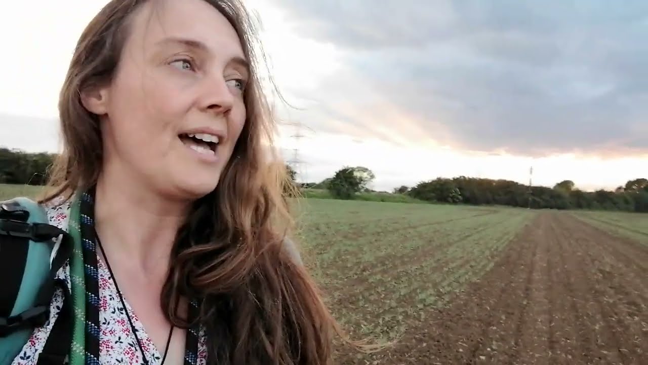 walking in fields with baby on back and dogs running off somewhere, singing a folk song called Sovay