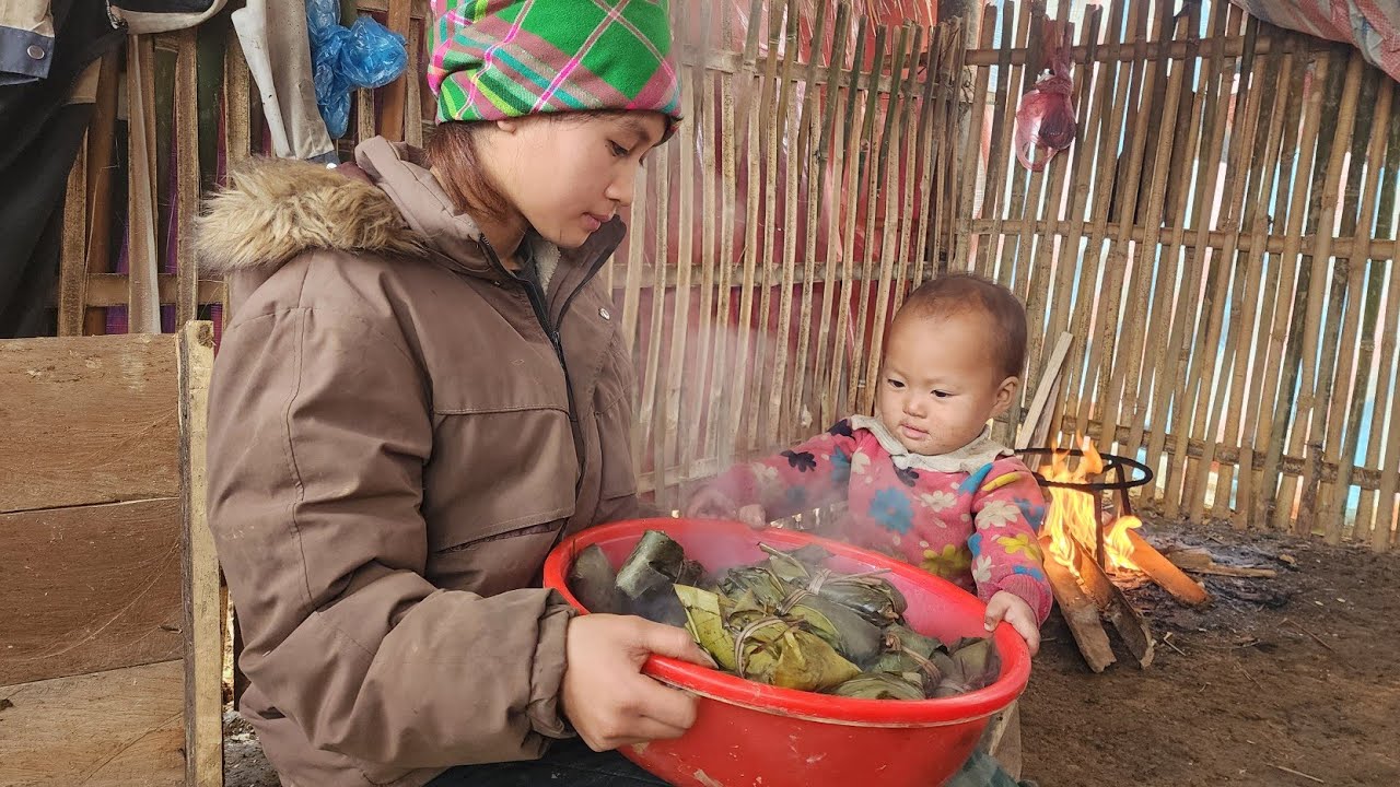 Mother and 13-month-old daughter wrap banh chung (Vietnamese rice cakes).