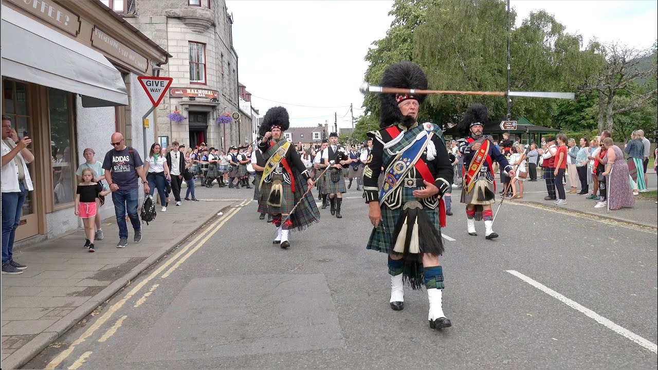 Mace flourish as Drum Majors lead the combined pipe bands back after 2023 Ballater Highland Games