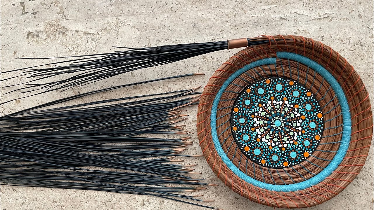 Adding dyed needles to a pine needle basket
