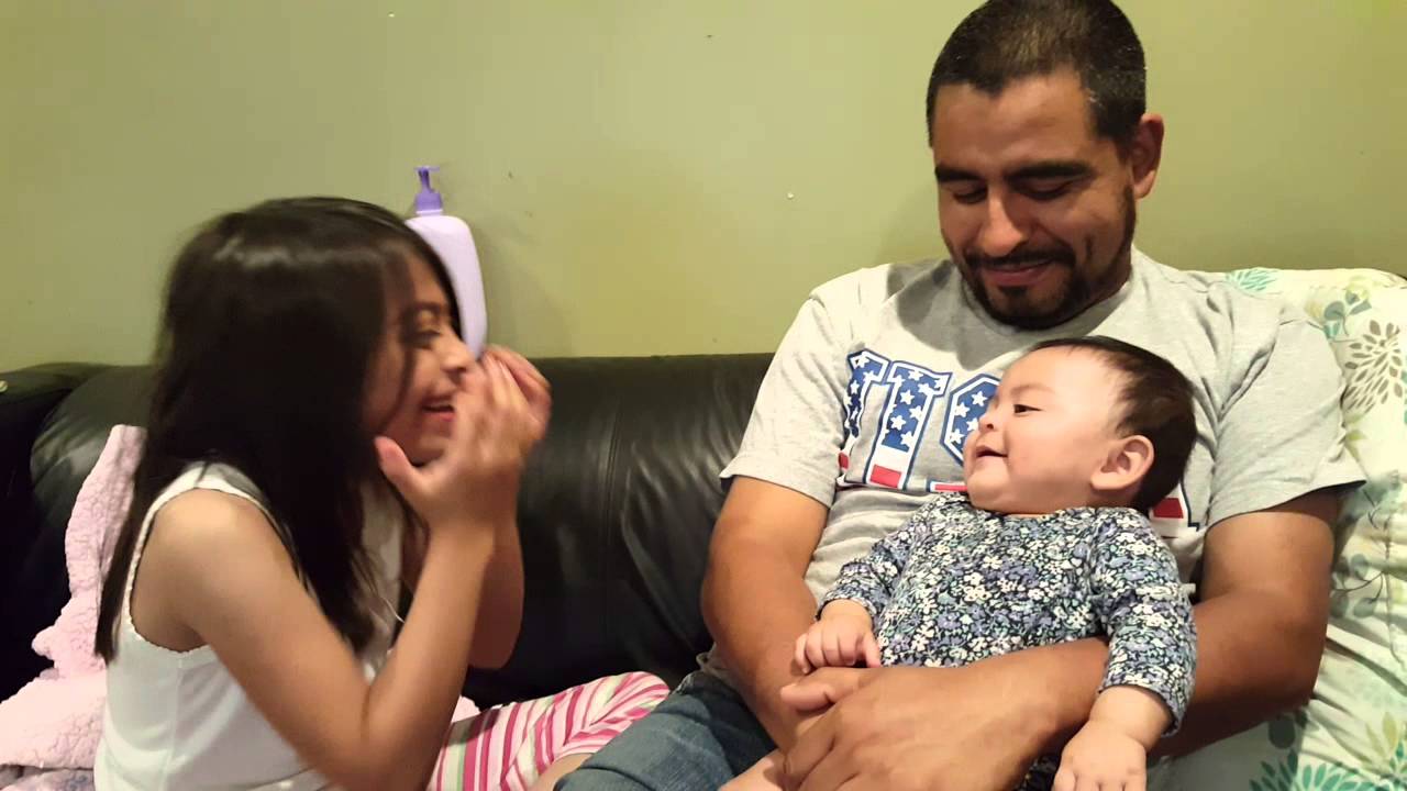 Baby enjoying peekaboo with big sister.