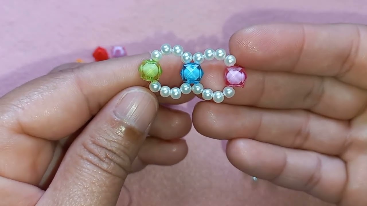 Pulseira entrelaçada com pérolas e quadradinhos coloridos