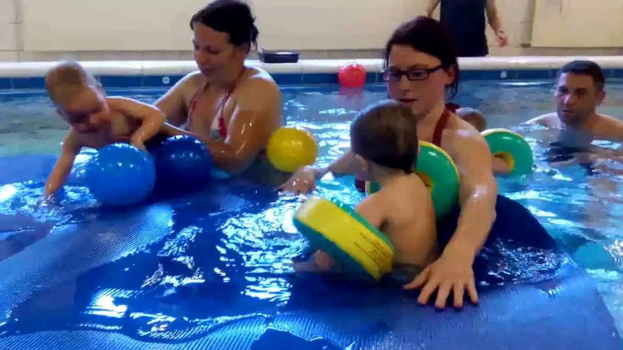 Kleinkindschwimmen mit Ball auf Matte
