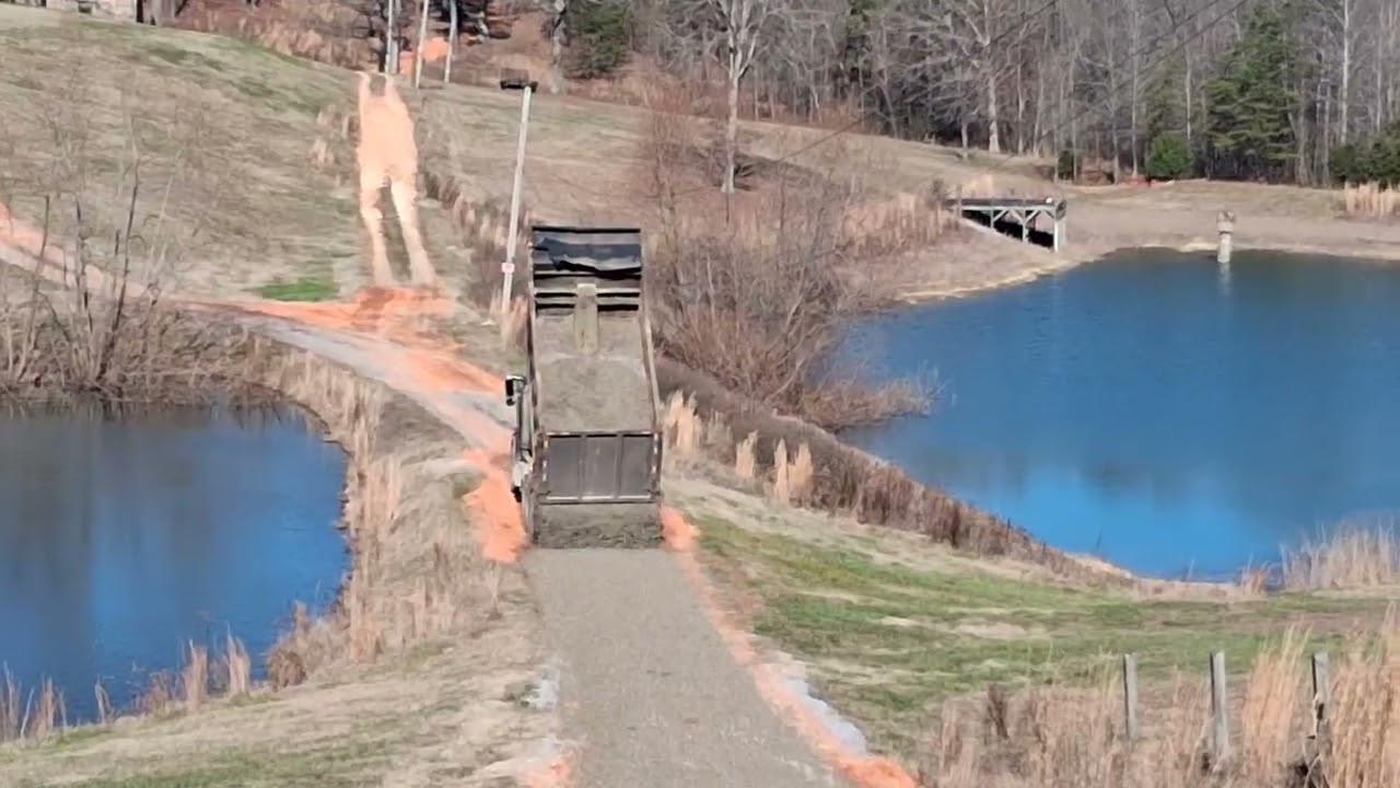 Long dump truck tailgating gravel