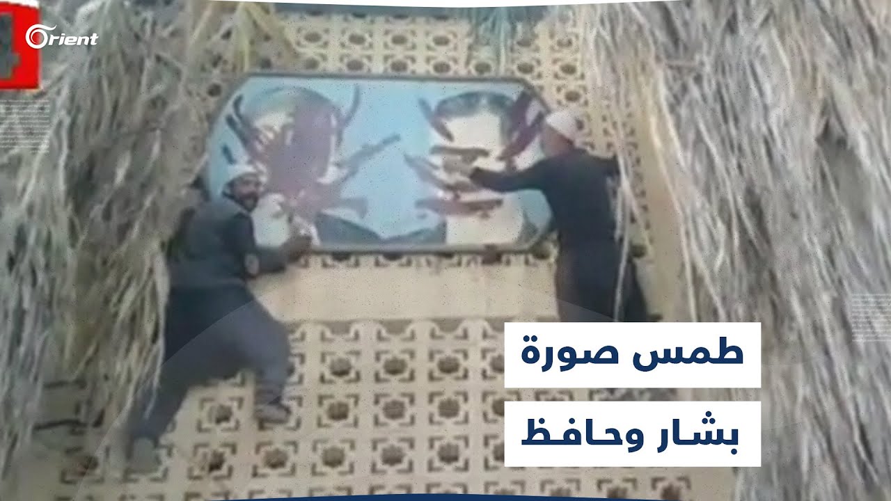 ثوار السويداء يطمسون صورة بشار وحافظ أسد في واجهة مبنى بلدية المزرعة بريف المحافظة الغربي