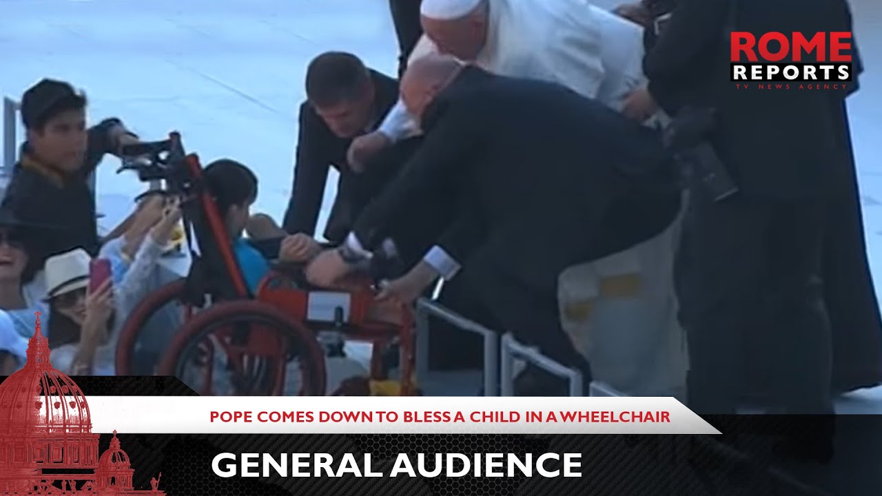 The Pope comes down from the altar to bless a child in a wheelchair