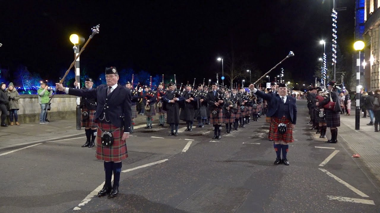 Massed Pipes and Drums marching by river Tay in Perth Scotland for 2020 Robert Burns Celebrations