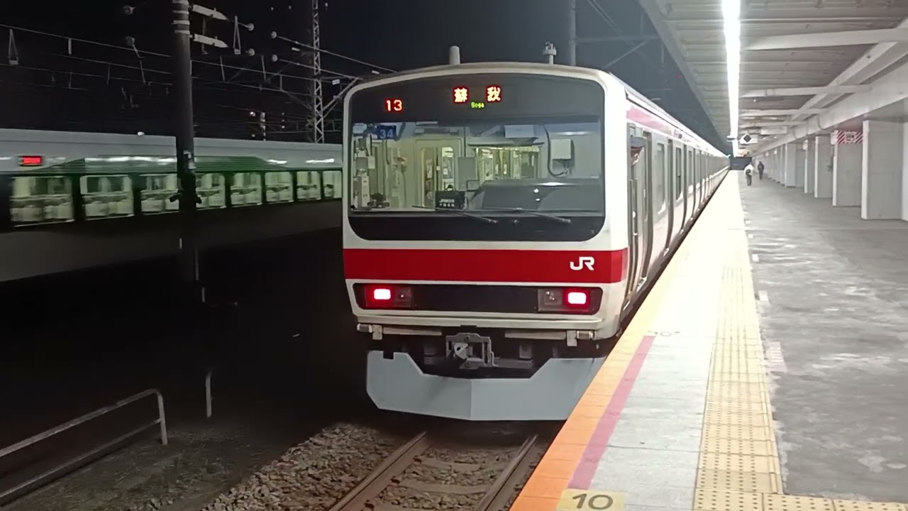 JR東日本209系500番台ｹﾖ34編成が各駅停車蘇我行きとして幕張豊砂駅1番線を出発する様子