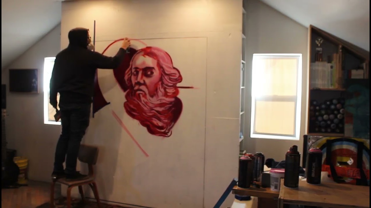 Bogzilla in the studio spray painting a monochromatic figure and ampersand.  #muralartist
