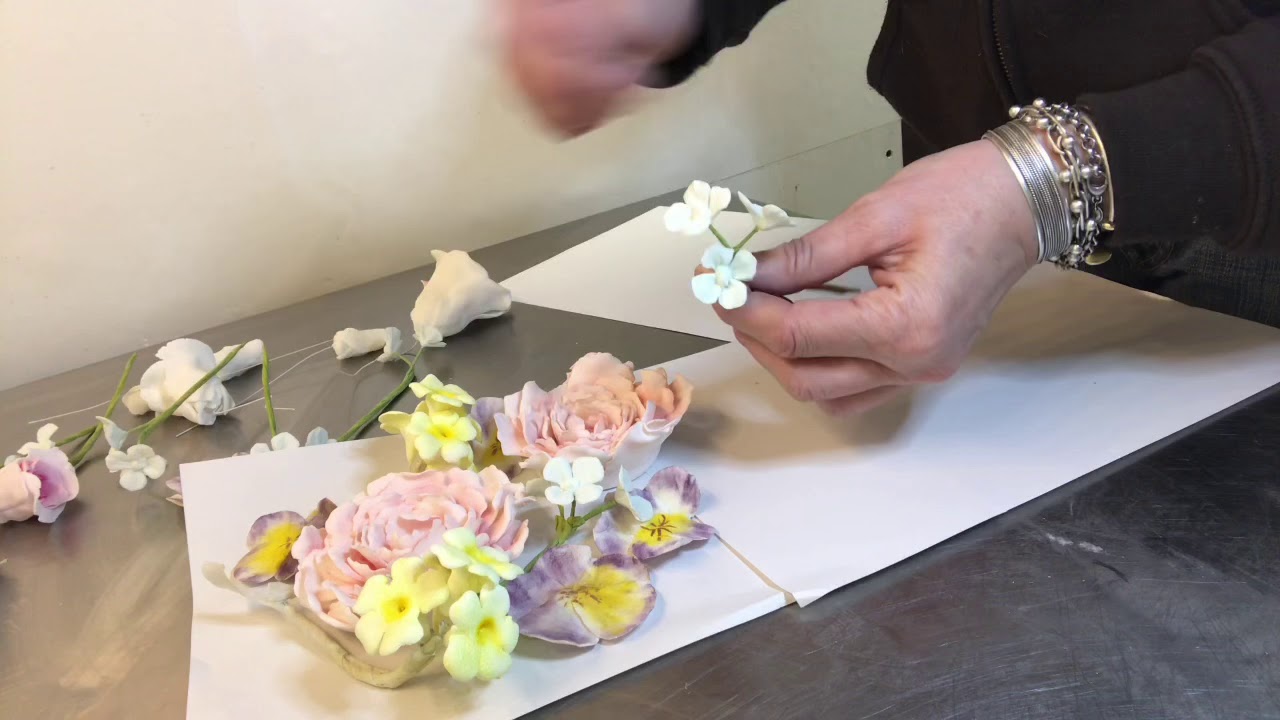 Arranging gum paste flowers on a cake