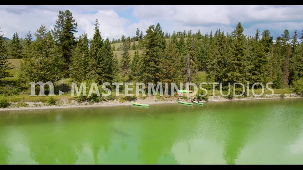 Aerial sliding along shore of Big Bar Lake with provincial park recreation site and canoes