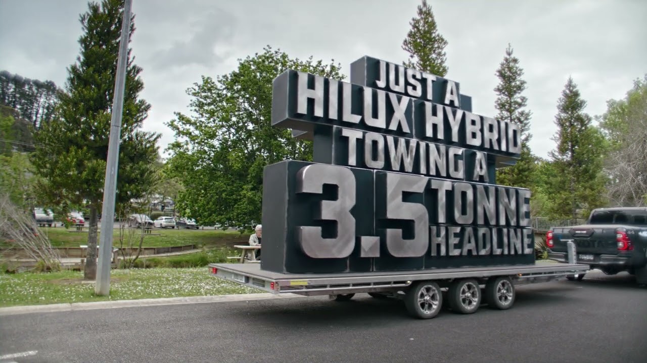 A couple watching a Hilux Hybrid tow a 3.5 tonne headline