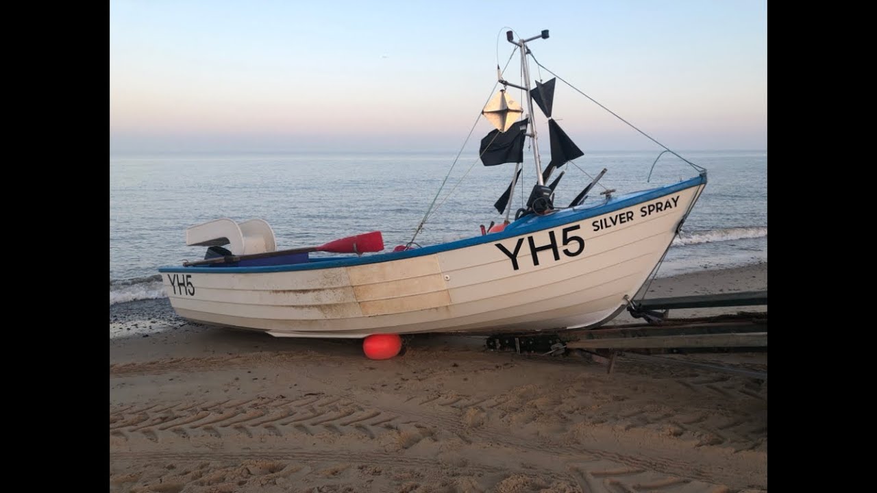 Beach boat sea fishing. Launching on a calm, misty day with some fish. Pike bait. Norfolk UK