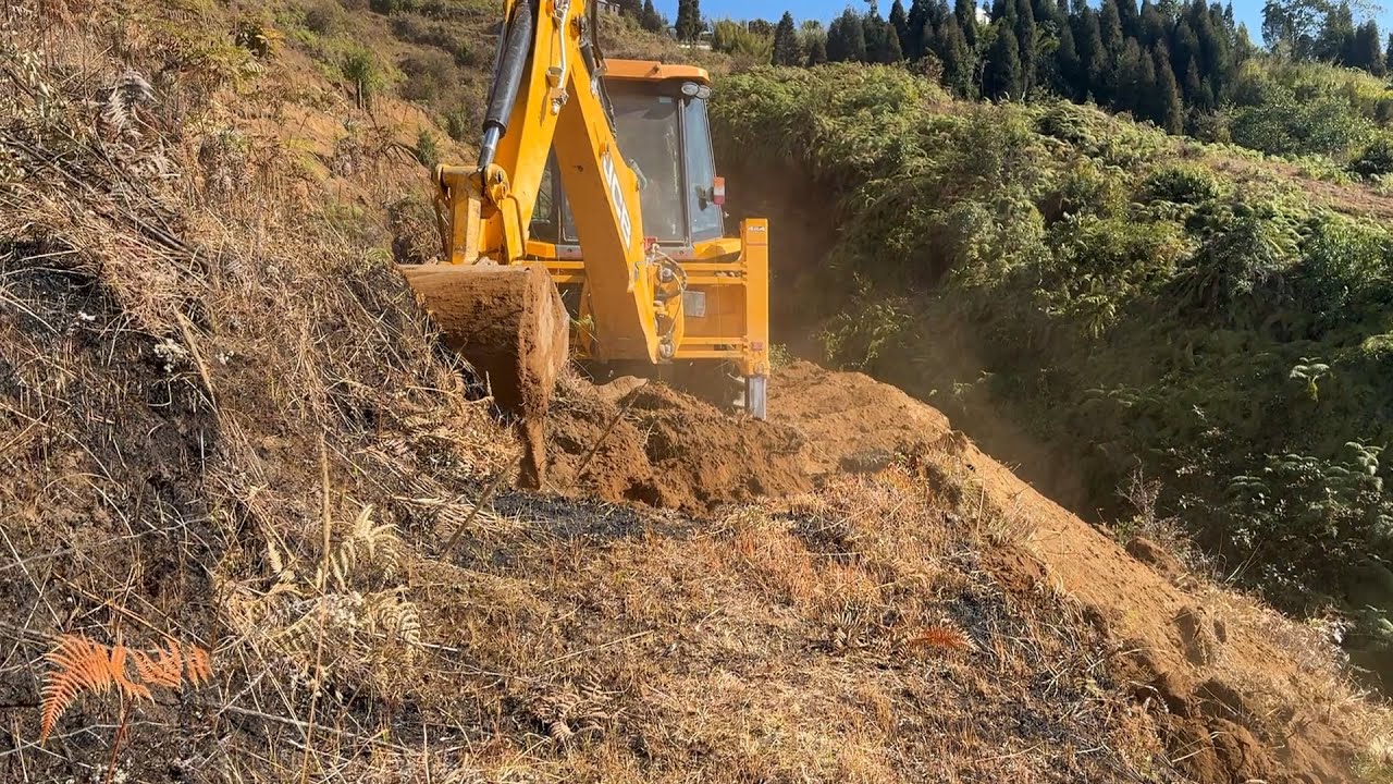Cutting Hillside for New Mountain Road by a Slippery Deep Cliff with JCB Backhoe