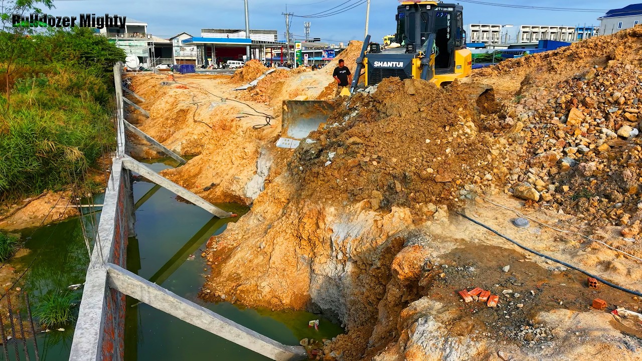 The driver's skills of the SHANTUI DH17C3 bulldozer push soil and rocks into the water, Delete