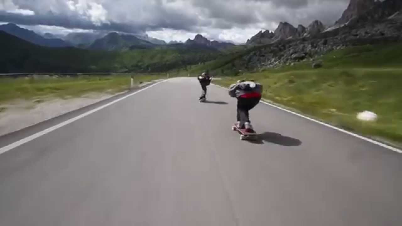 Crazy downhill skateboarders flying by cyclists