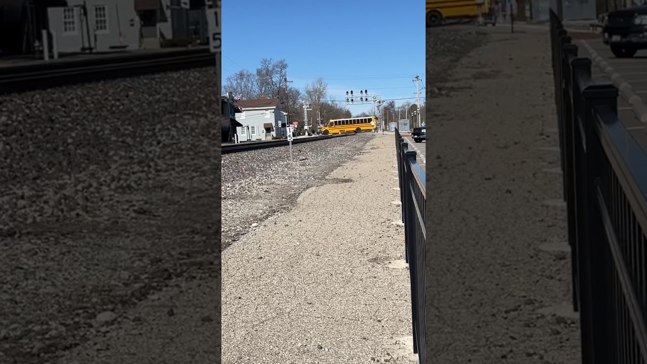 School bus dangerously crosses an activated railroad crossing with train coming!