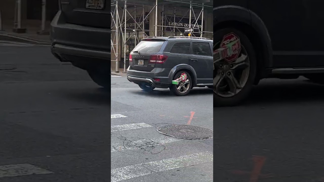 NYC driver causes a scene loudly driving around with boot lock on vehicle tire