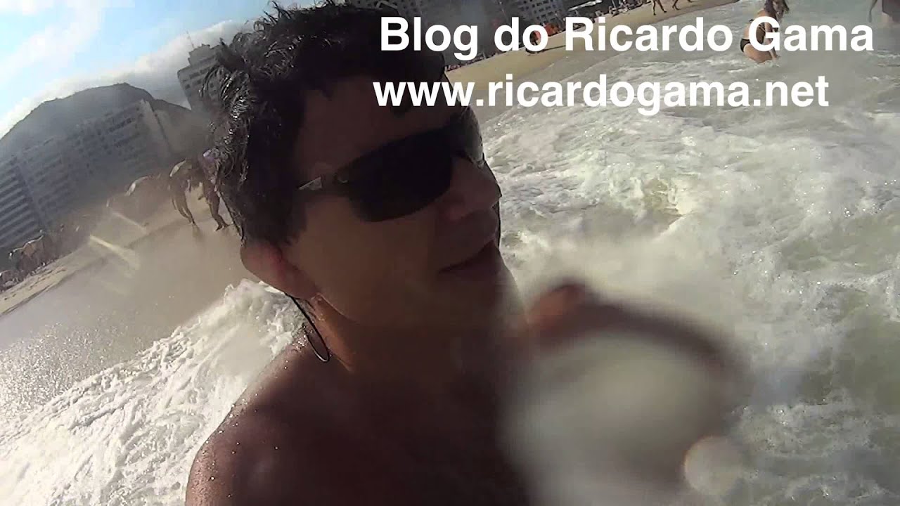 Crianças nas ondas brincando e tomando muito “caldo”  na praia de Copacabana com papai