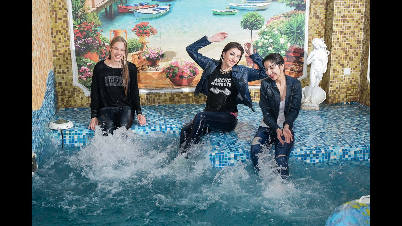 three beautiful girls in wet clothes in the pool