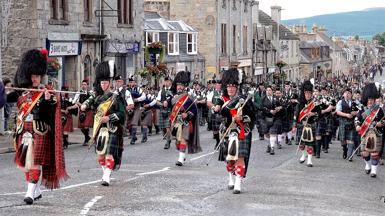 Drum Majors lead the massed Pipes & Drums march back into town after 2024 Dufftown Highland Games