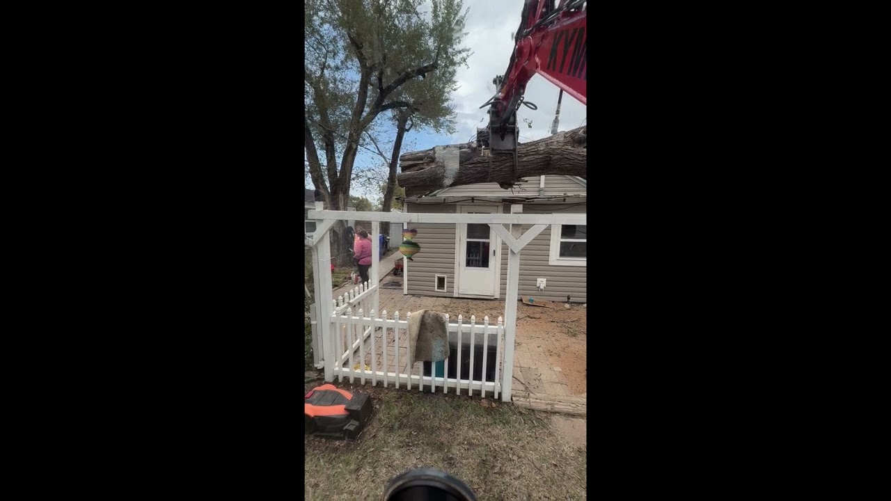 Kymron XH42D removing a Tree that had fallen on top of a house from storm damage.