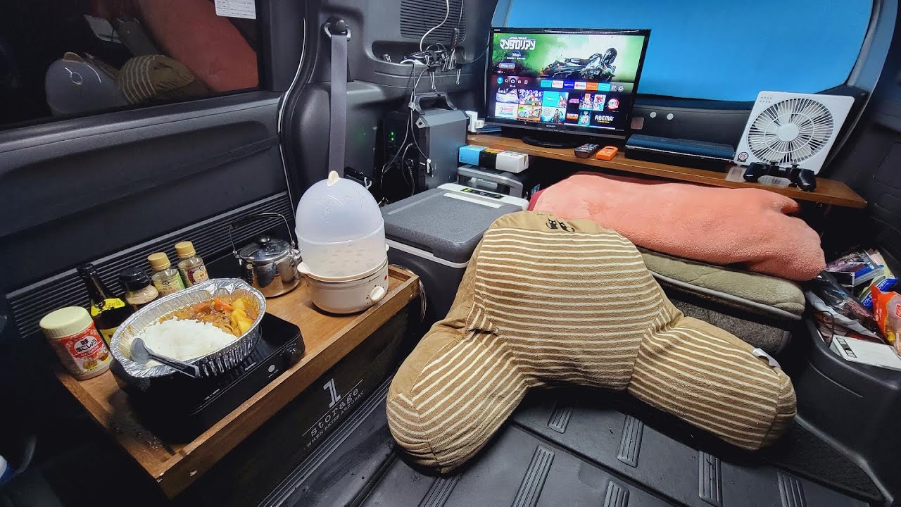 雨降る車内で装備を確認しながら料理を楽しむ車中泊