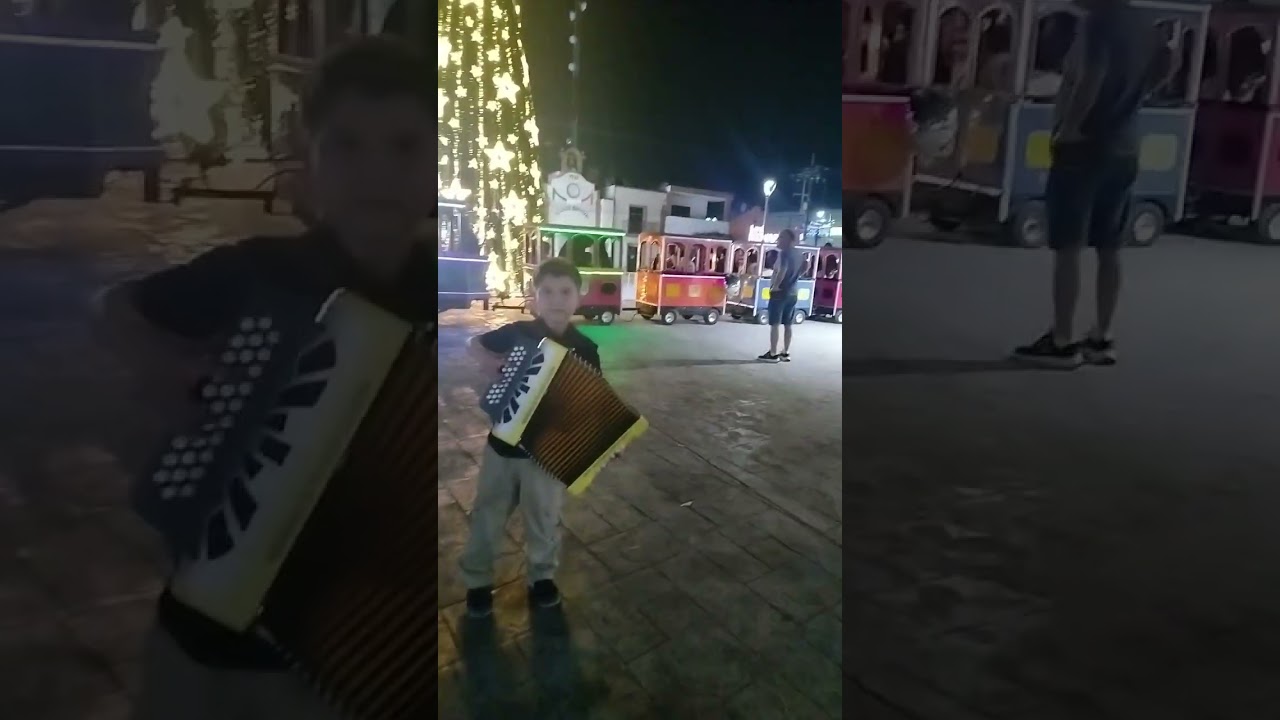 Niño tocando acordeón en plaza