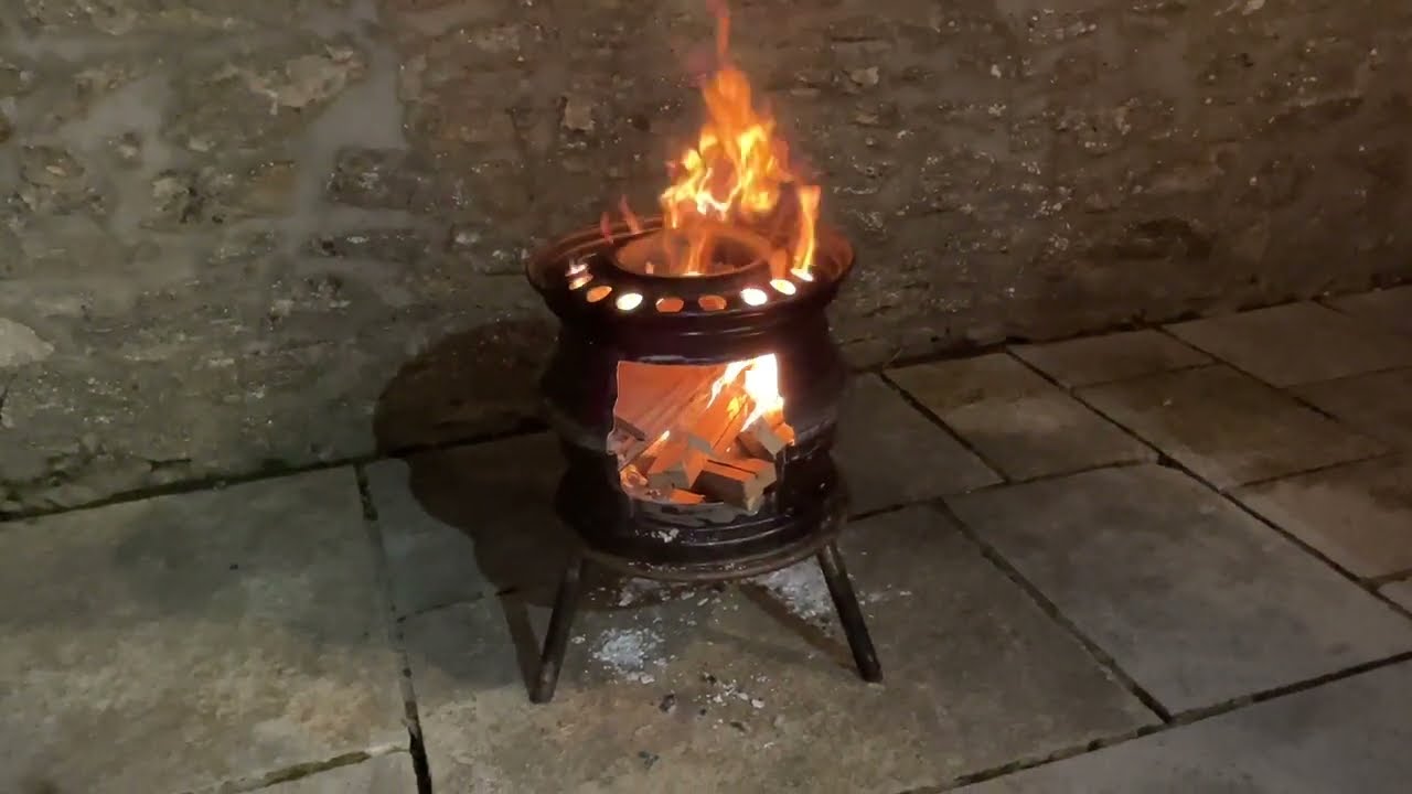 Log burner fire pit patio heater made from old scrap car wheels. Rustic upcycling.