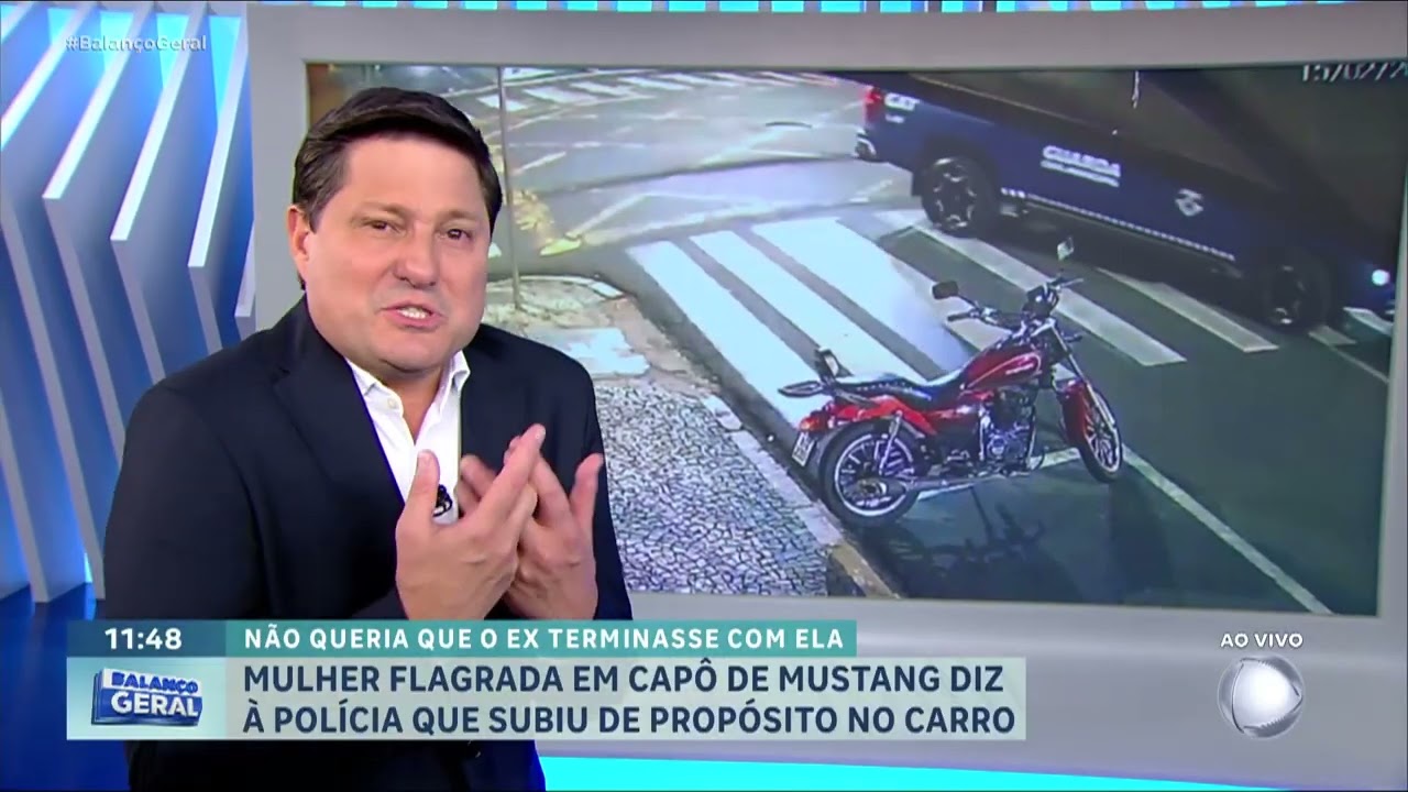 Mulher flagrada sobre capô de luxo em movimento se justifica na policia