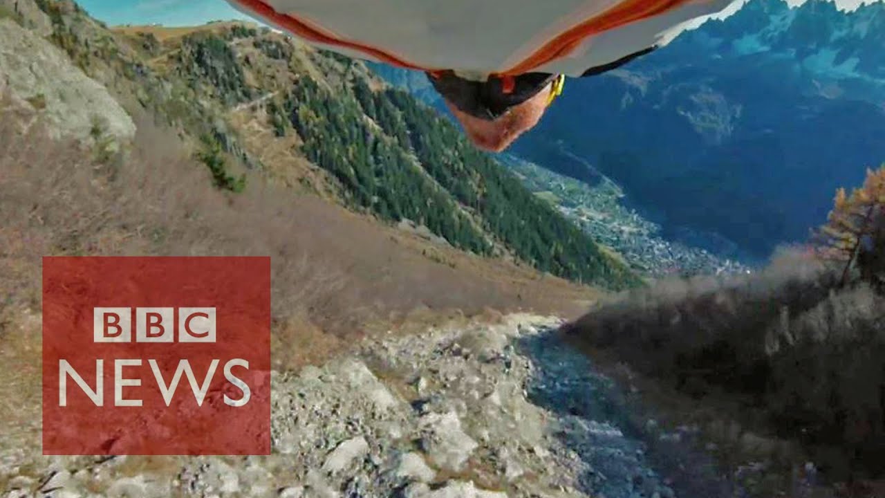 Amazing 'high five' by wingsuit pilot
