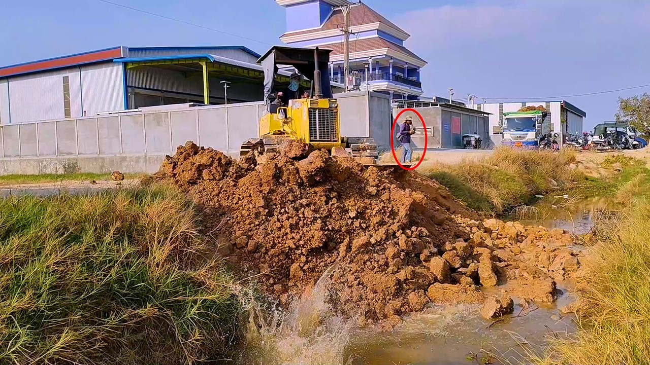 Smartly start up new project delete canal to fill land field by dozer D20 pour soil with dump truck 