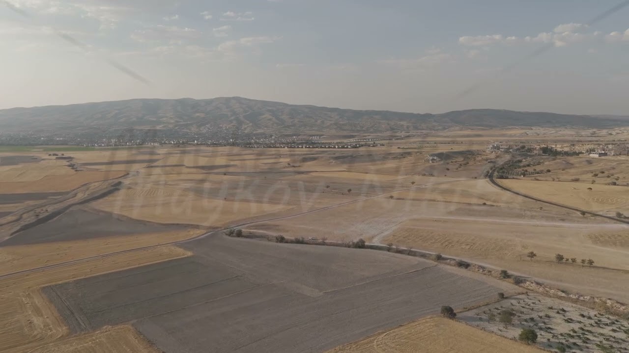D-Log M. Goreme, Nevsehir, Turkey. Aerial view of Cappadocia plateau with agricultural fields, ro...