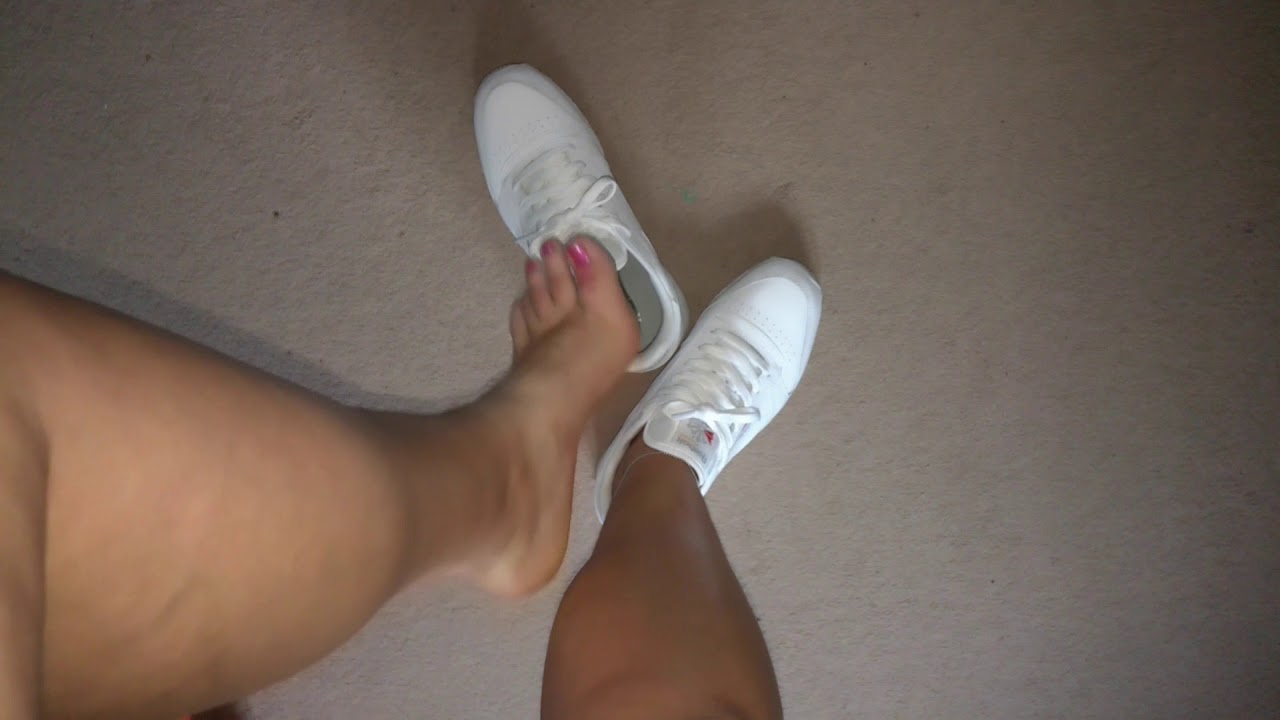 Sockless girl removing Reebok Classic