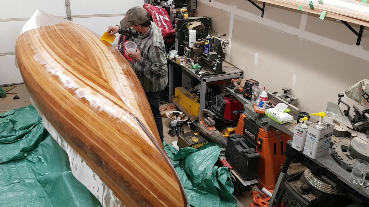 Installing fiberglass and epoxy on a cedar strip canoe.