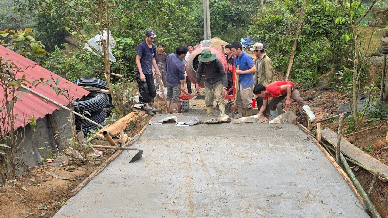 Vợ chồng H.mong cho nắn đường Lùng Pục những mét Bê tông đầu tiên chị Thôn. Nguyễn Tất Thắng