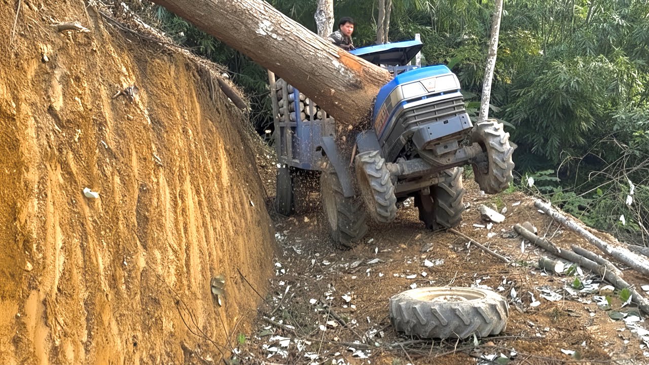 “Dangerous Logging Route: Agricultural Vehicle Struggles on Cliffside Road”